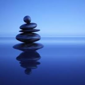 Smooth, spa rocks stacked on still water with a blue background to show internal calm and peace resulting from seeing a counselor or therapist for stress management.