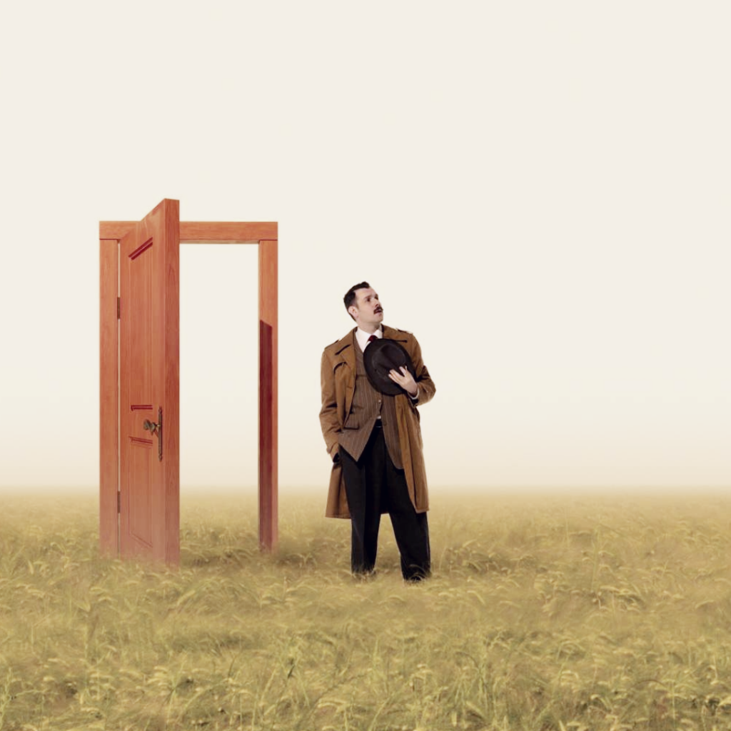 A man stands on the other side of an open door, looking to the sky and the open plain around him